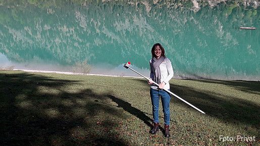 Foto zum Thema Ausbildung zum Hygienekontrolleur: Zu sehen ist Veronika, die für das Gesundheitsamt arbeitet. Sie hält ein Gerät in der Hand, mit dem sie die Wasserqualität im bayerischen Sylvensteinspeicher prüft.